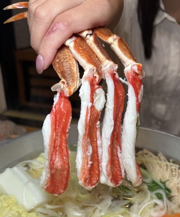 かにしゃぶのかに身を鍋にくぐらせるところ