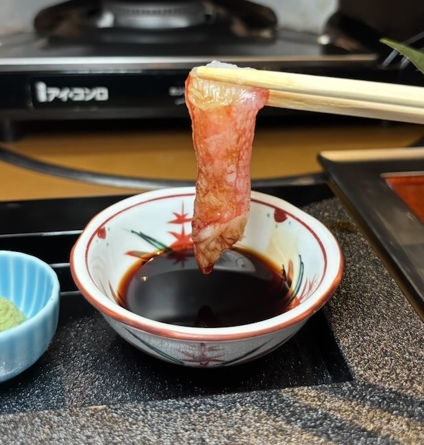 かにしゃぶをたれにつけて食べる様子