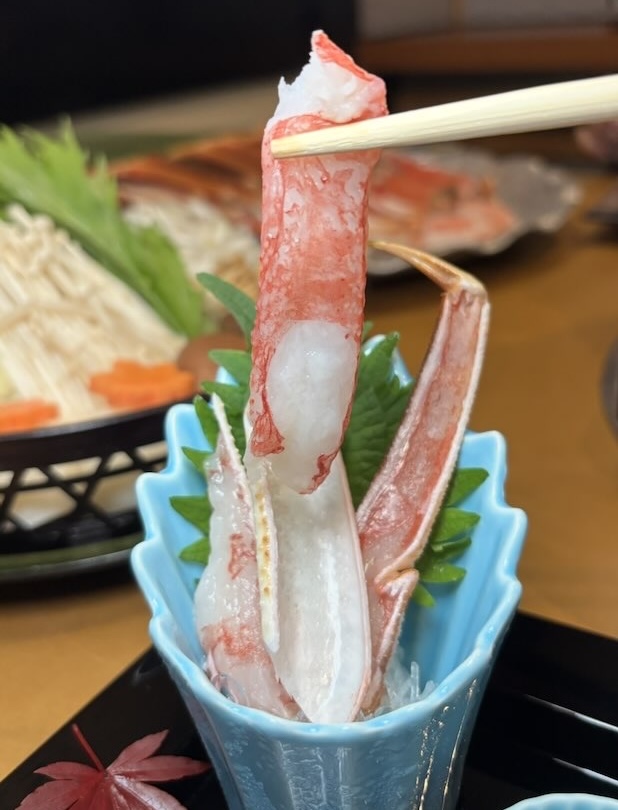 かに刺身を箸で持ち上げた写真